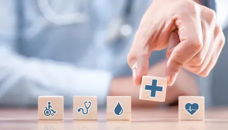Hand arranging wood block with healthcare medical icon