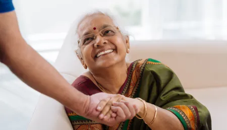 South Asian women shaking hands and smiling